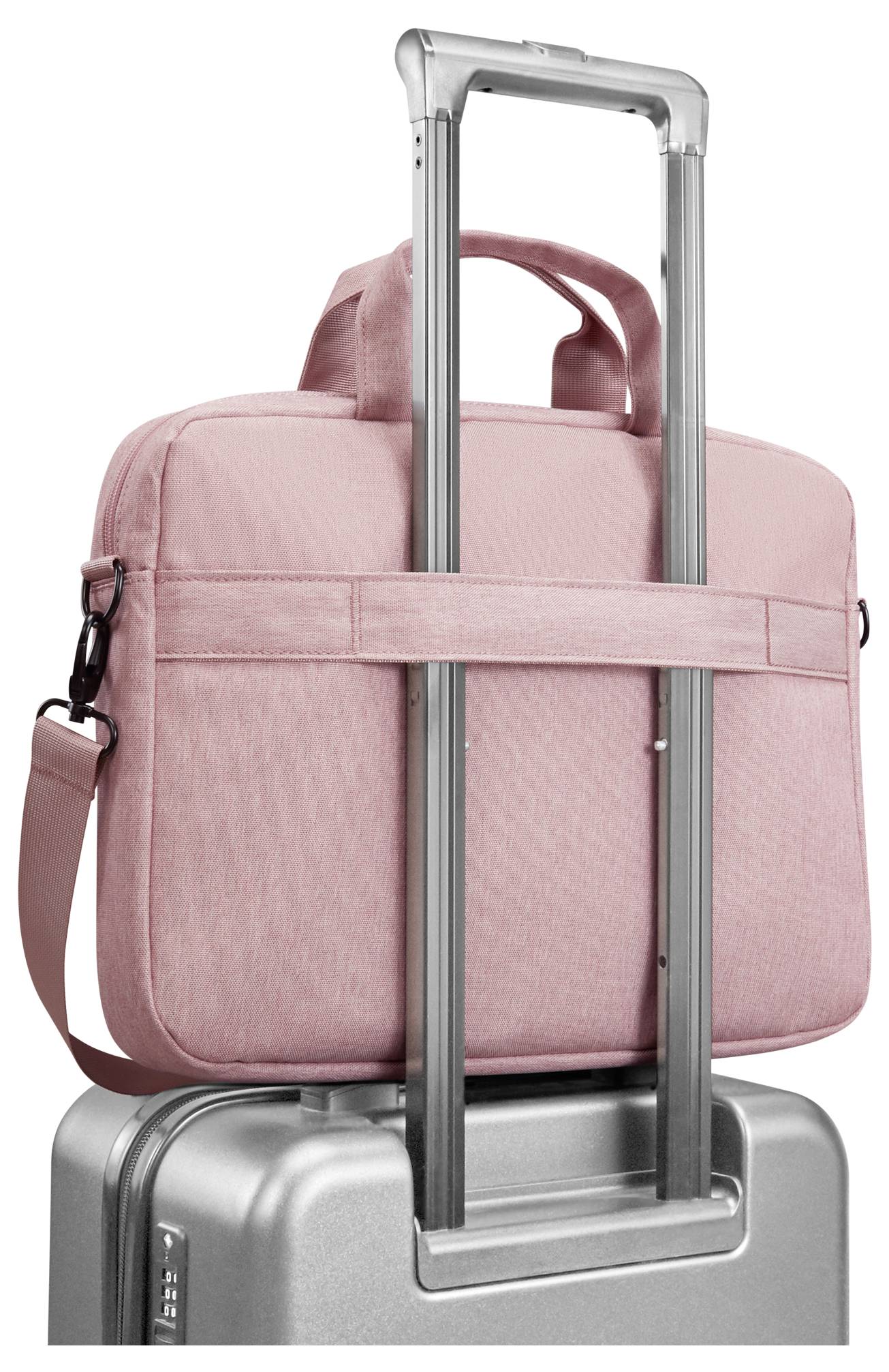 Sac à dos rose pour ordinateur portable attaché à la poignée extensible d'une valise roulante argentée.