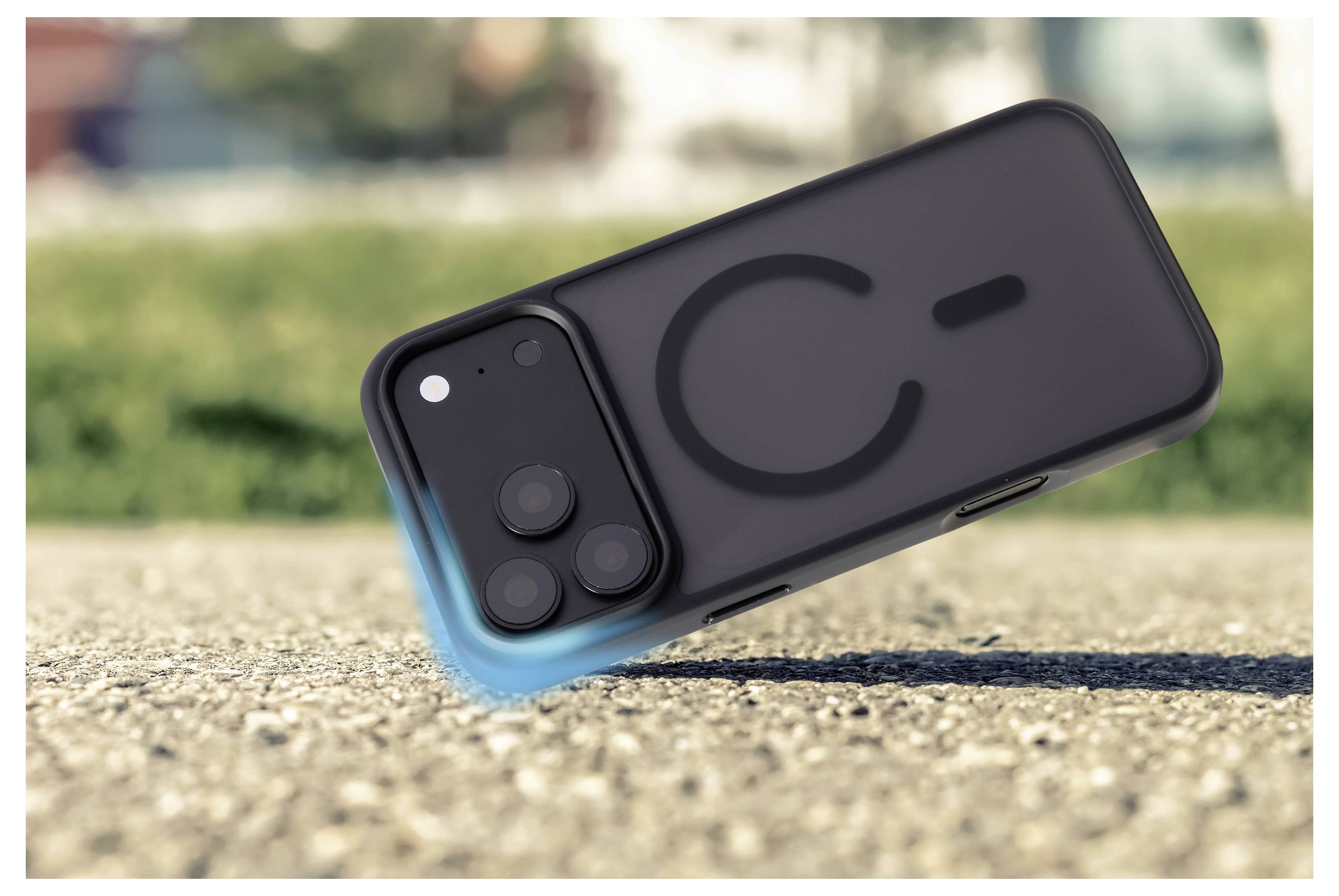 Un smartphone noir repose incliné sur une surface extérieure rugueuse, montrant son dos avec des objectifs de caméra double et un grand logo stylisé « C ».