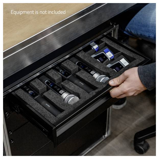 # Traduction<br><br>Ouverture d'un tiroir doublé de mousse contenant plusieurs microphones sans fil et de petits appareils audio ; le texte indique « L'équipement n'est pas inclus ».