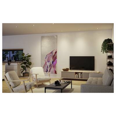 Salon moderne avec canapé, deux fauteuils, table basse, meuble TV et grand art mural abstrait dans un intérieur chaleureux et minimaliste.