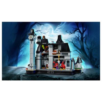 Ensemble de jeu LEGO-style de maison hantée avec une tour d'horloge, des pièces ouvertes en vue de section, et des figurines de fantômes sous une lune pleine brillante dans une forêt effrayante.