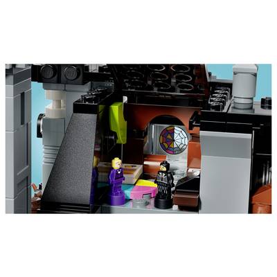Deux figurines LEGO se tiennent à l'intérieur d'une chambre en forme de château coloré avec une ouverture en vitrail arquée et des accents néon lumineux.