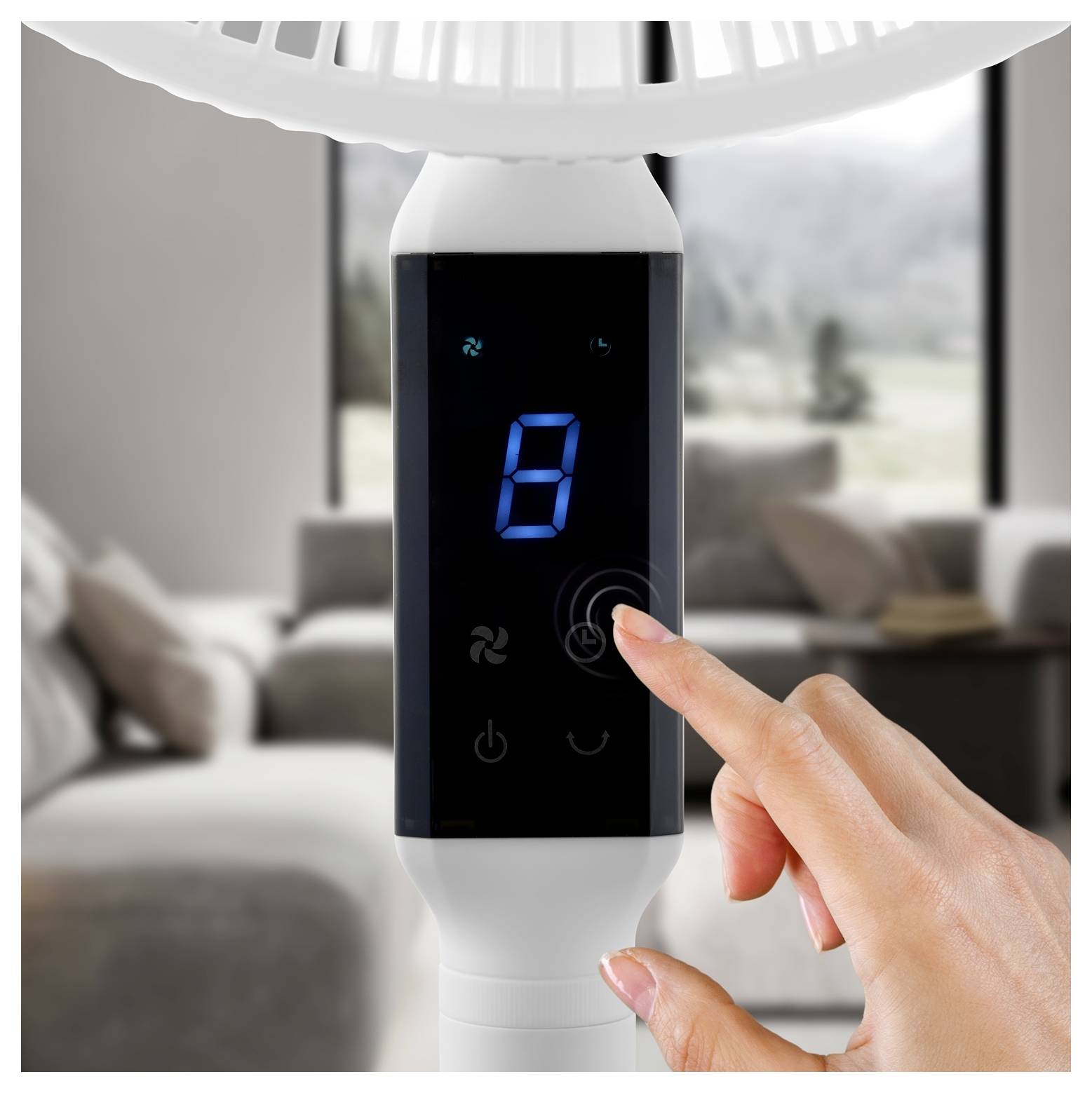Ajustement manuel d'un panneau de commande numérique sur un ventilateur de sol blanc, avec le chiffre 8 bleu affiché.