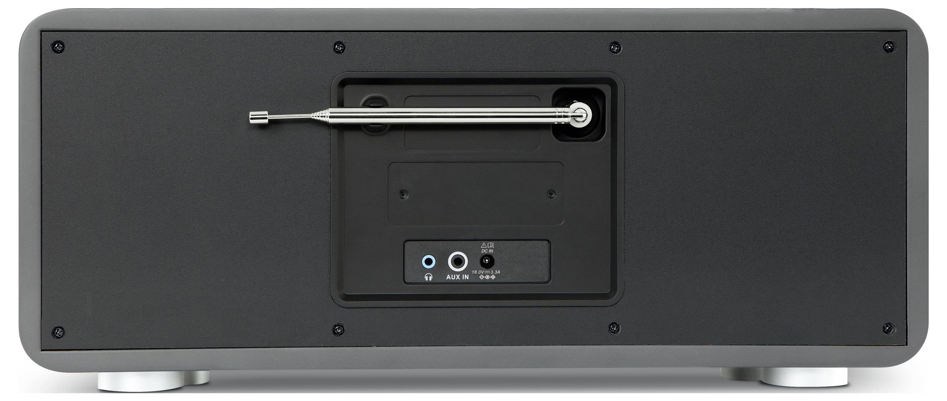 Vue arrière d'un dispositif audio noir montrant un panneau de commande central encastré avec des ports et un levier horizontal, probablement un haut-parleur ou un amplificateur.