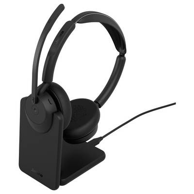Casque sans fil supra-auriculaire noir sur un socle de charge, avec microphone perche et câble connecté.