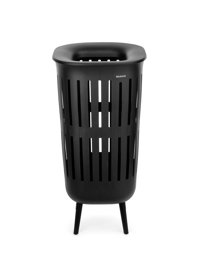 Panier à linge noir aéré avec un rebord arrondi et trois pieds, présenté sur un fond blanc.