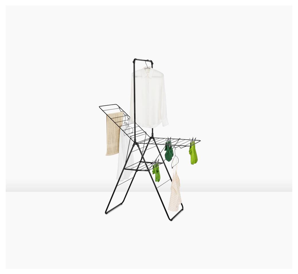 Séchoir pliable noir avec vêtements et serviettes suspendus sur fond blanc.
