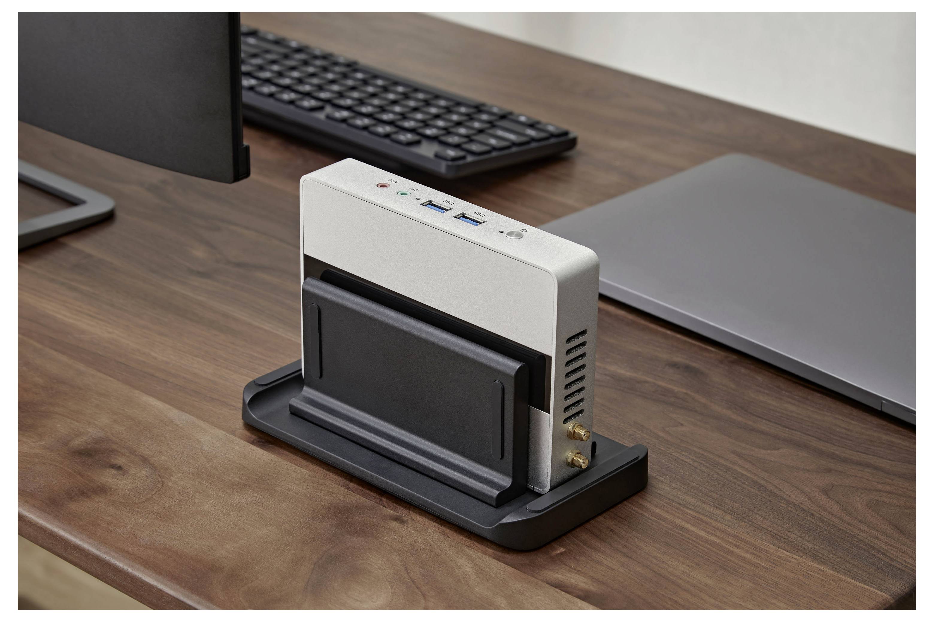 Station d'accueil compacte de bureau avec support pour téléphone intelligent ou tablette, placée sur un bureau en bois à côté d'un clavier et d'un ordinateur portable.