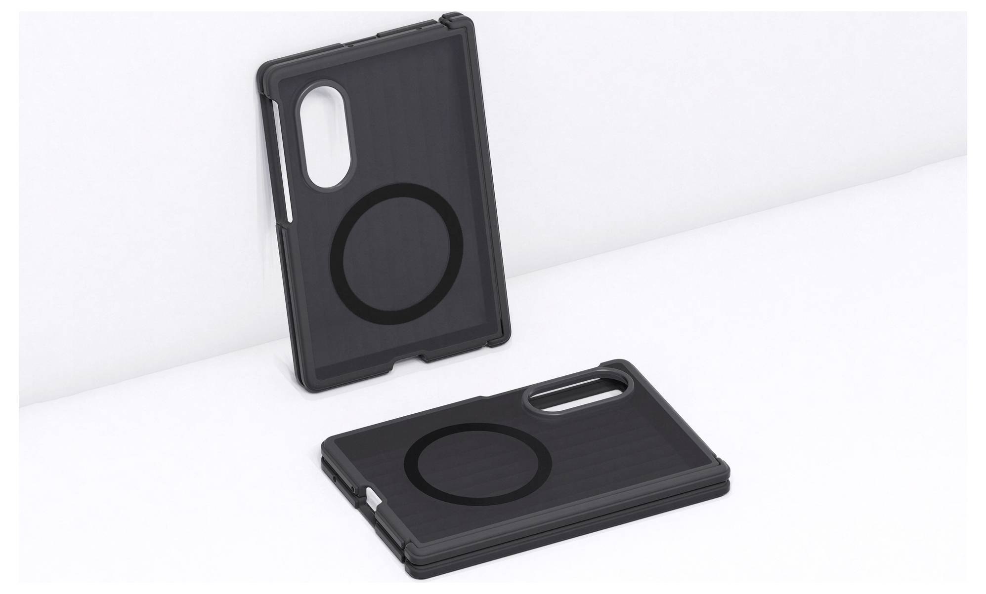 Deux étuis de smartphone noirs avec des bagues de style MagSafe circulaires, l'un debout et l'autre allongé sur une surface blanche.