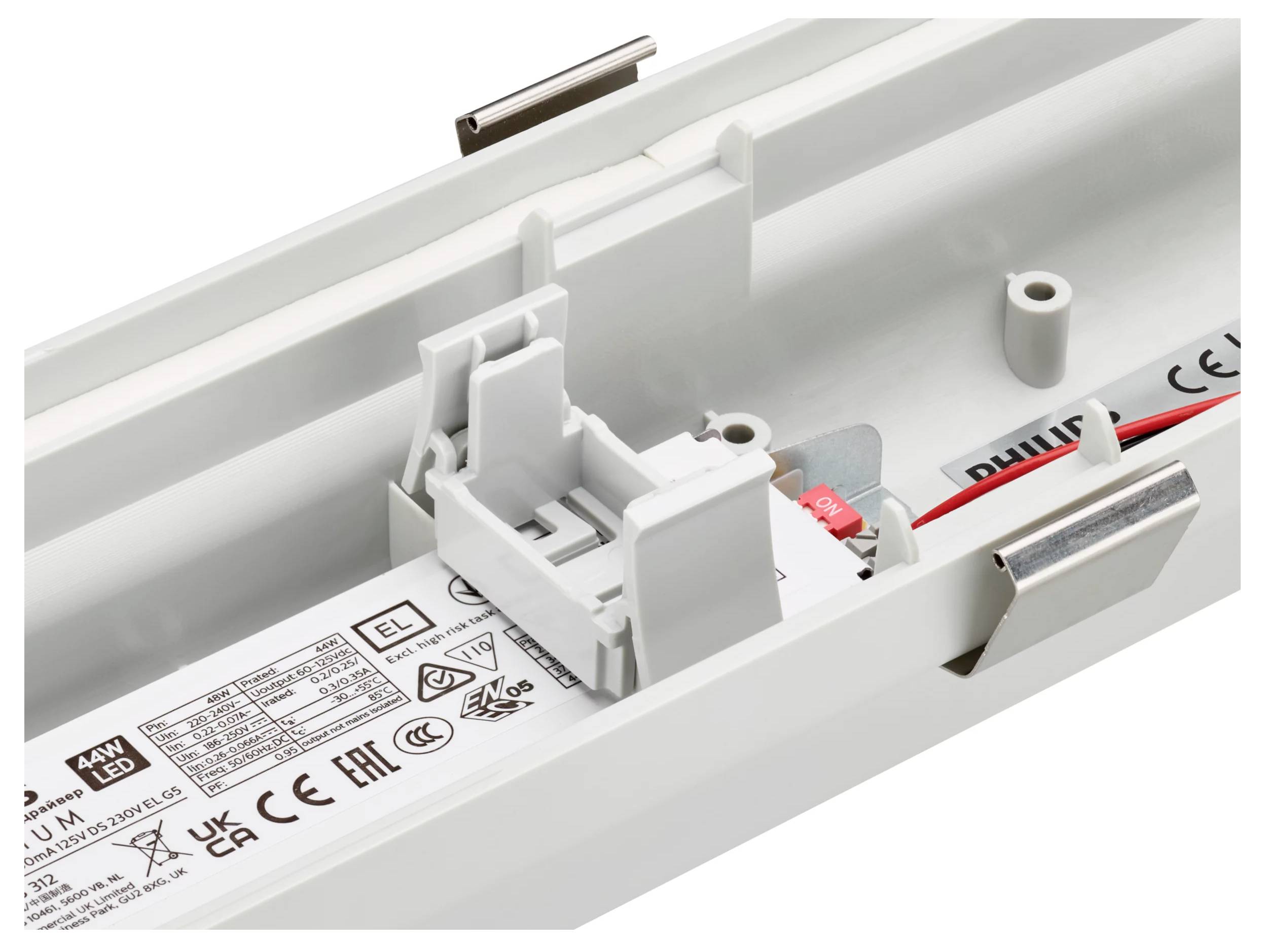 Gros plan d'un boîtier interne de luminaire LED avec câblage et support de montage à l'intérieur d'un boîtier blanc, montrant les composants étiquetés et les fils d'alimentation rouge et noir.