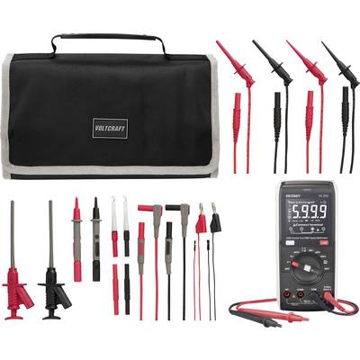 Kit multimètre Voltcraft avec étui de transport, sondes de test et assortiment de câbles de mesure et d'adaptateurs présentés sur un fond blanc.