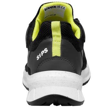 Vue arrière d'une chaussure de sécurité noire et jaune néon avec le marquage « S1PS » et une semelle blanche épaisse sur un fond uni.