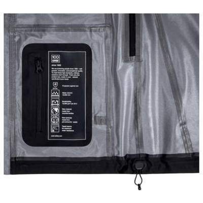 Gros plan d'une pochette de rangement à façade transparente sur un sac gris avec fermeture éclair, montrant une étiquette noire avec des icônes d'entretien et de caractéristiques, probablement un compartiment organisateur.