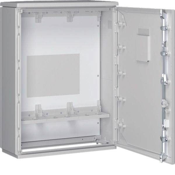 Armoire électrique grise ouverte avec porte à charnière, panneau de montage interne et loquets de verrouillage visibles sur le côté.