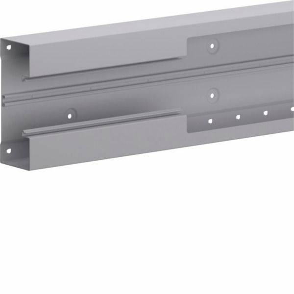 Support ou canal métallique gris fixé au mur avec des trous de boulonnage, présenté isolé sur fond blanc.