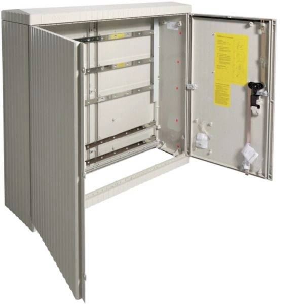 Armoire de distribution électrique métallique ouverte avec portes articulées et rails de montage, montrant l'intérieur et une étiquette d'instruction jaune sur la porte intérieure.