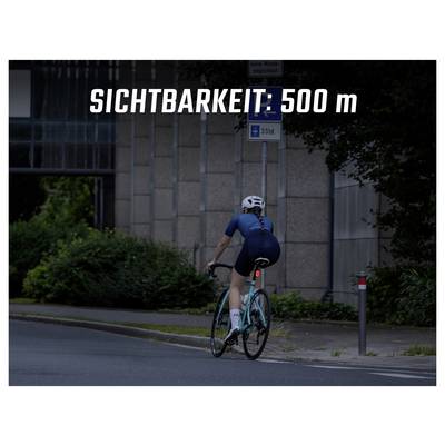 Cycliste dans une rue sombre ; incrustation « VISIBILITÉ : 500 m » avertit d'une mauvaise visibilité.