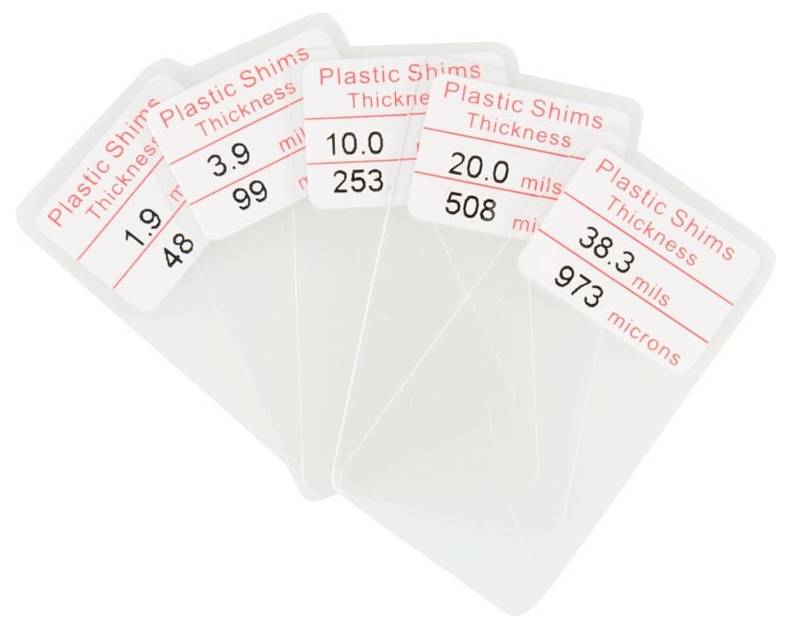 Ensemble de cinq cartes d'épaisseur de cales en plastique translucide étiquetées avec des mesures en mils et microns.