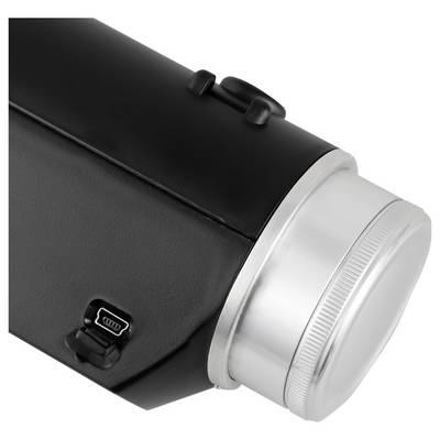 Gros plan d'une lampe de poche ou lanterne noire avec un anneau frontal rainuré argenté et un port de recharge