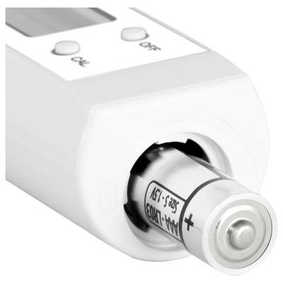 Gros plan d'un testeur de batterie avec une batterie AA insérée, montrant les boutons indicateurs de polarité '+' et 'OK'/'Mauvais' sur le dessus.
