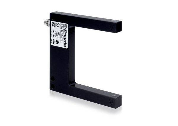 Capteur photoélectrique industriel noir en forme de C avec étiquette et connecteur de câble, isolé sur fond blanc.