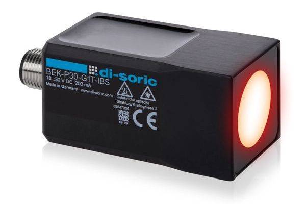 Capteur photoélectrique industriel noir avec connecteur métallique fileté et lentille rouge brillante, étiqueté di-Soric BEK-P3O-G1T-IBS.