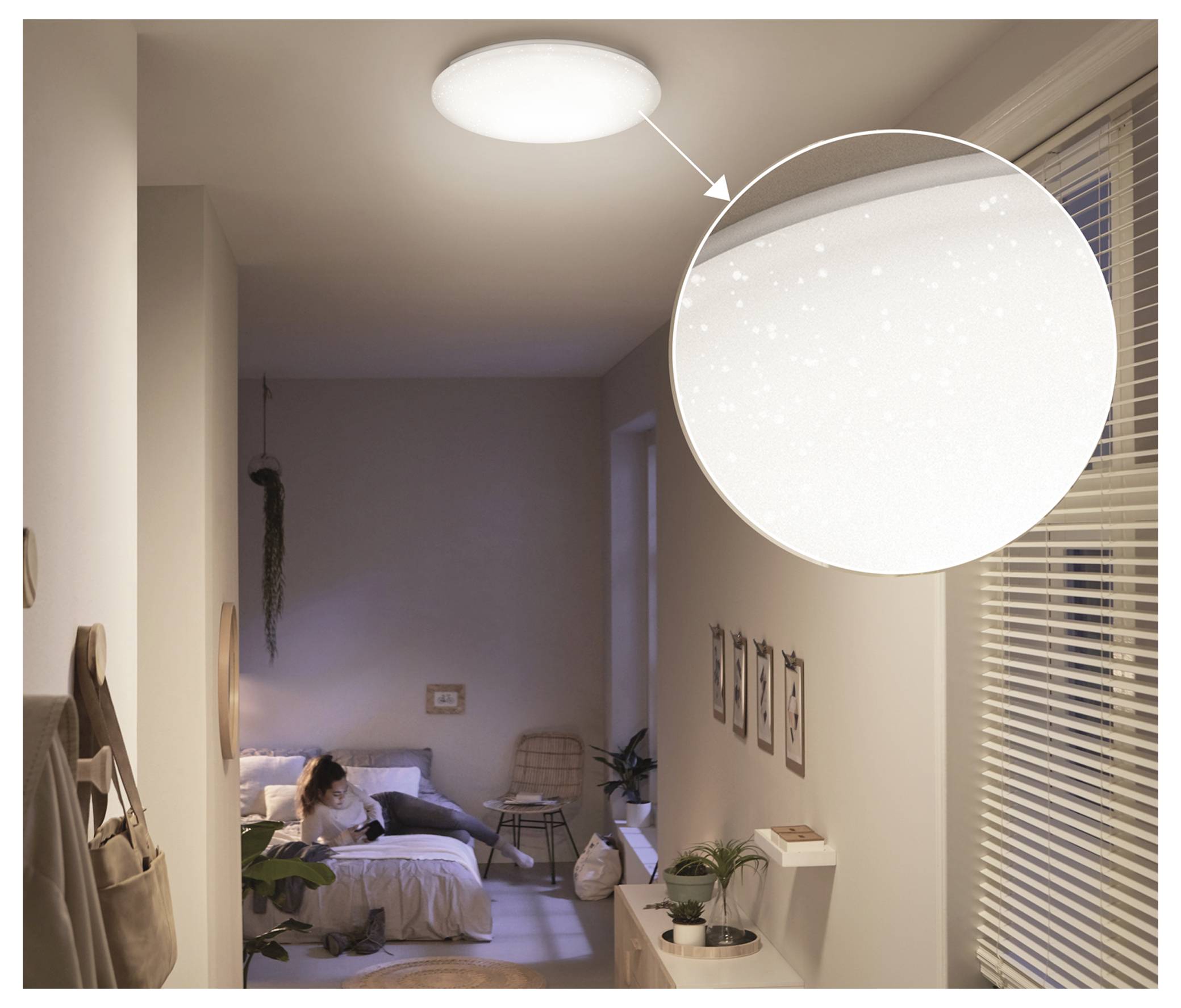 Chambre à coucher au crépuscule avec une personne sur le lit et une lampe de plafond présentée en encart agrandi, mettant en évidence sa lueur douce.