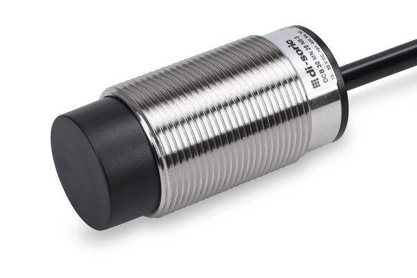 Gros plan d'un capteur de proximité inductive cylindrique en métal avec une face de détection noire et un câble attaché sur un fond blanc.