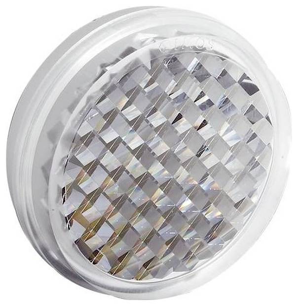 Gros plan d'une lentille lumineuse ronde et transparente à facettes ou d'un réflecteur avec un rebord blanc translucide sur un fond blanc.
