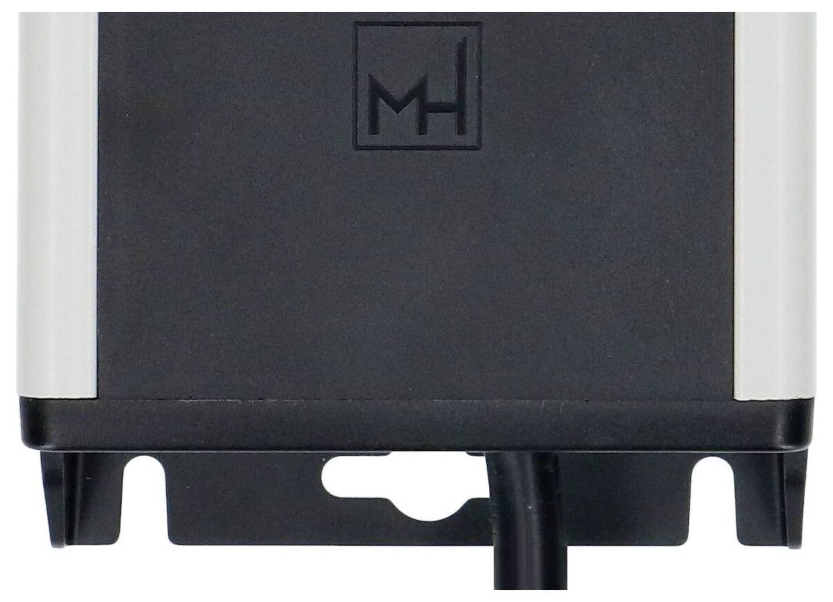 Gros plan d'une base de dispositif électronique ou d'appareil noir et argenté avec un logo « MH » sur le devant.