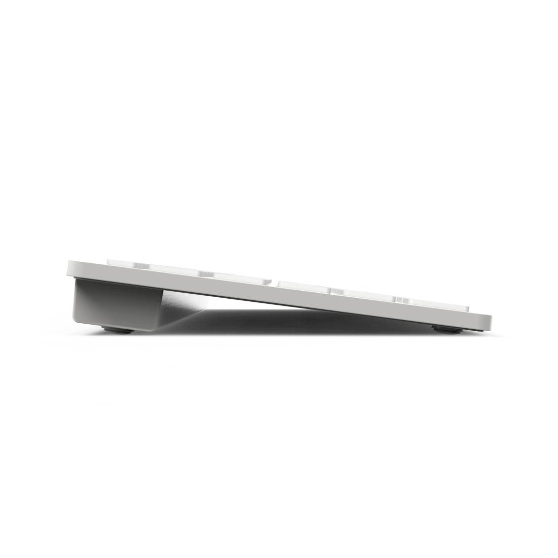 Profil latéral d'un clavier argenté fin posé à plat sur un fond blanc.