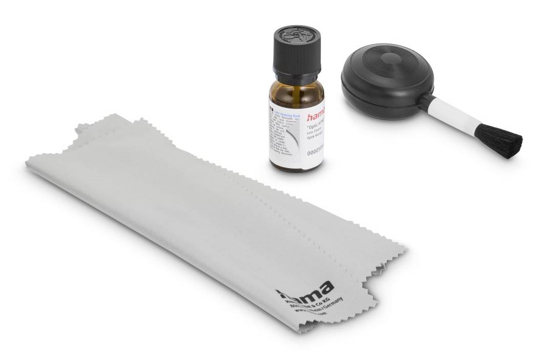 Kit de nettoyage avec un chiffon de polissage, un petit flacon de liquide de nettoyage et une brosse soufflante en caoutchouc sur un fond blanc.