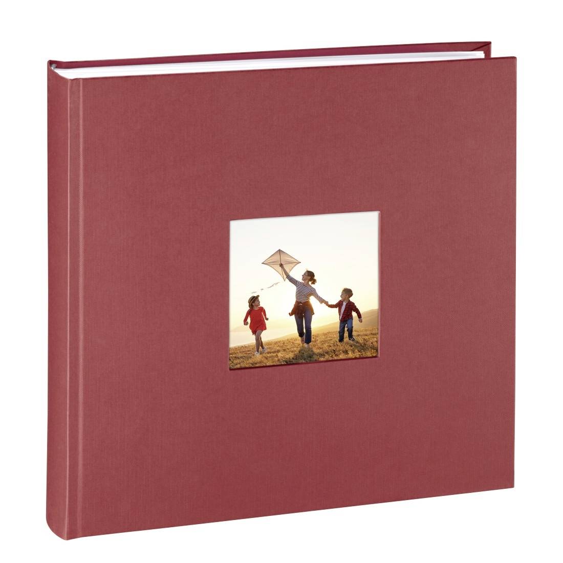 Album photo rouge avec une petite photo de couverture montrant trois enfants courant à l'extérieur en faisant voler un cerf-volant au coucher du soleil.
