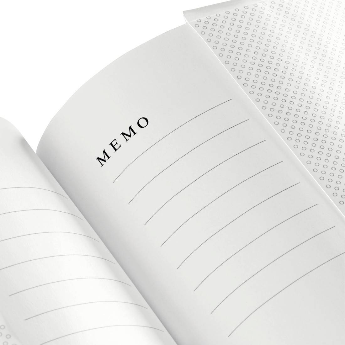 Carnet mémo ouvert avec pages lignées et couverture vierge, vu en gros plan.
