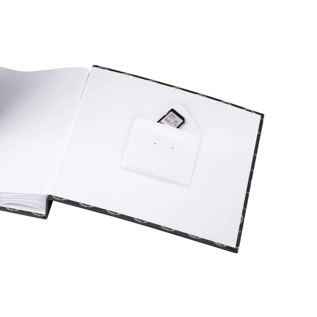 Livre ouvert avec une poche blanche contenant une carte mémoire sur la page de droite, suggérant un usage de stockage ou d'album photo.