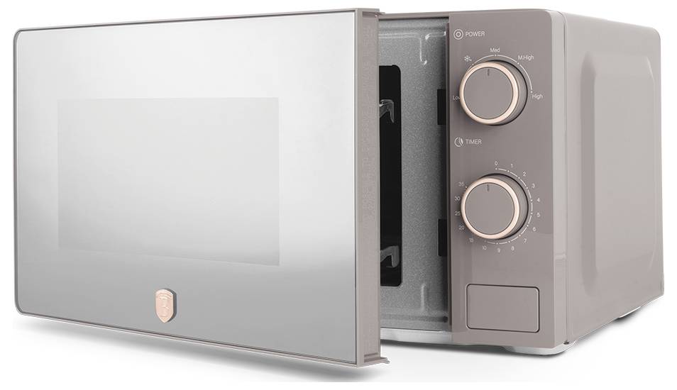 Four à micro-ondes compact de comptoir avec porte ouverte, montrant l'intérieur et deux cadrans de contrôle sur le côté droit.