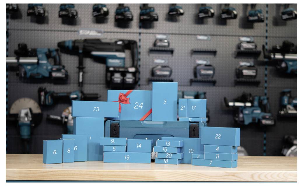 Des boîtes cadeaux numérotées en bleu arrangées comme un calendrier de l'Avent empilé sur une table en bois, avec des voitures jouets affichées floues derrière elles.