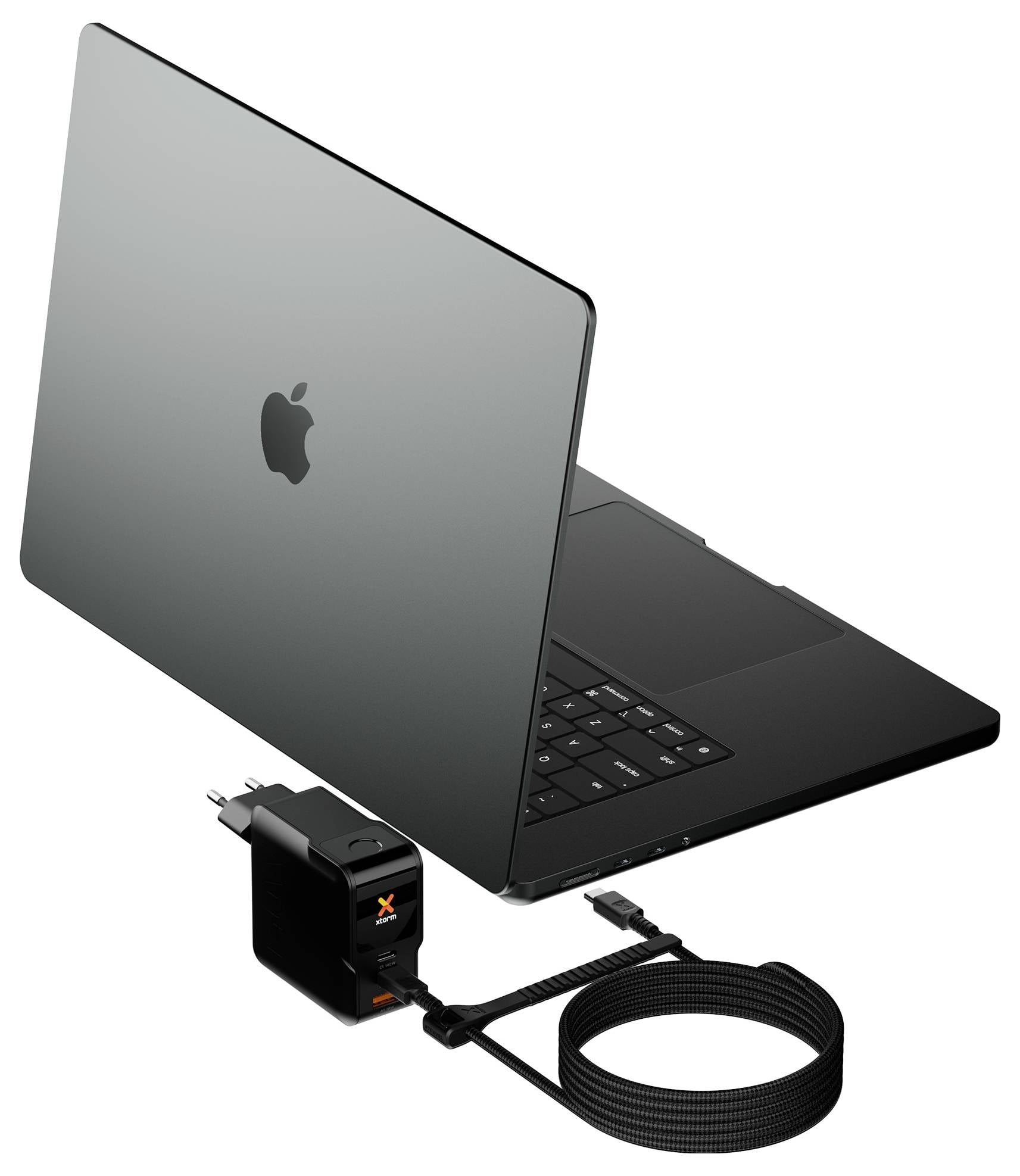 Un MacBook Apple fermé avec un adaptateur secteur externe noir et un câble de charge enroulé connecté à côté.