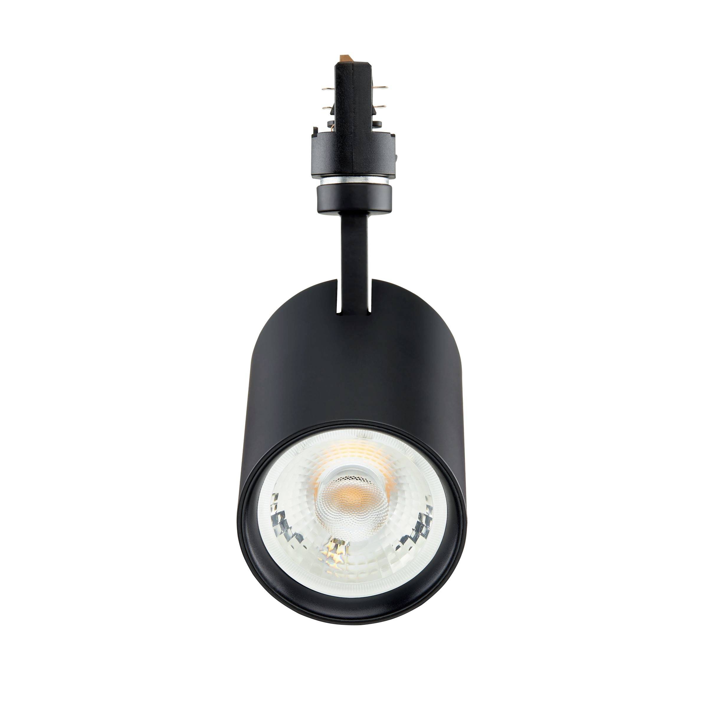 Projecteur monté sur rail noir avec une tête de lampe LED ronde sur fond blanc.