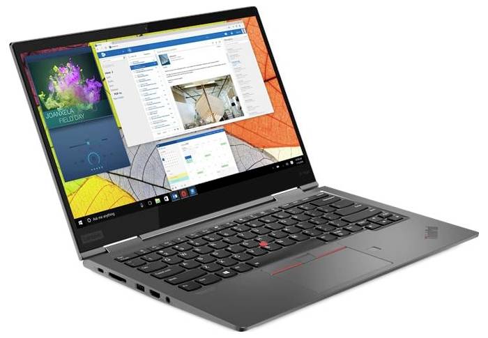 Ordinateur portable Lenovo argenté ouvert selon un angle, affichant un bureau Windows avec plusieurs fenêtres d'application à l'écran.