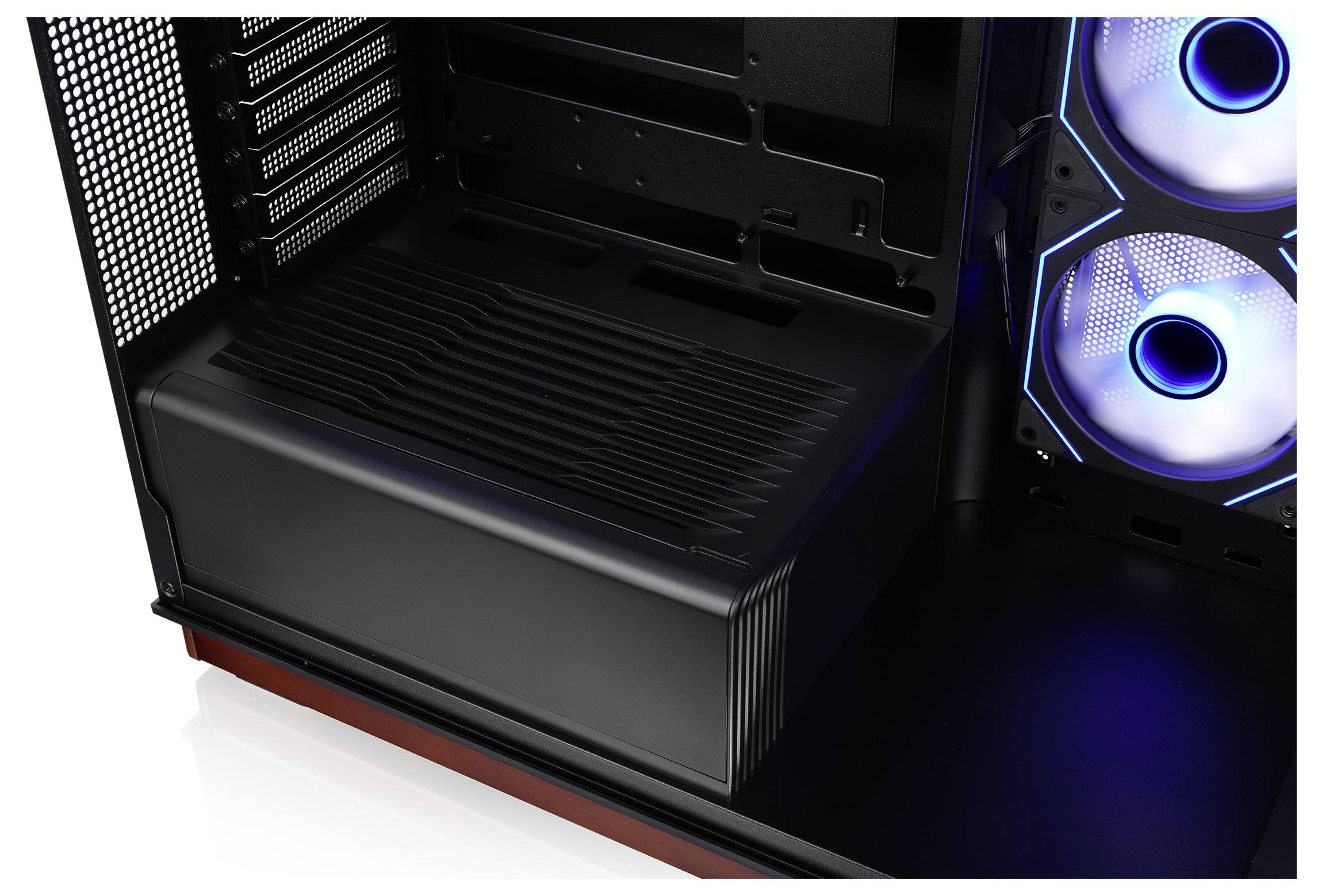 Intérieur d'un boîtier de PC de bureau noir avec deux ventilateurs de refroidissement illuminés en bleu et un cache d'alimentation en bas.