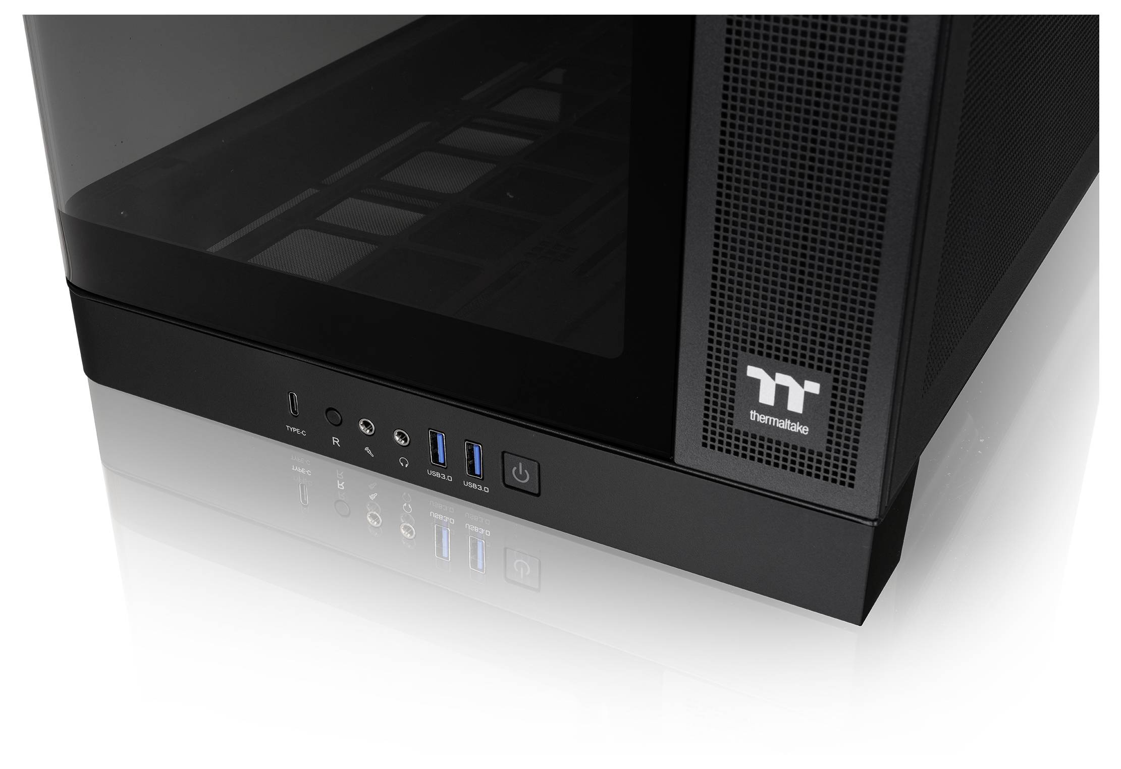 Gros plan du panneau avant d'un boîtier d'ordinateur Thermaltake noir avec bouton d'alimentation, prises audio et ports USB.