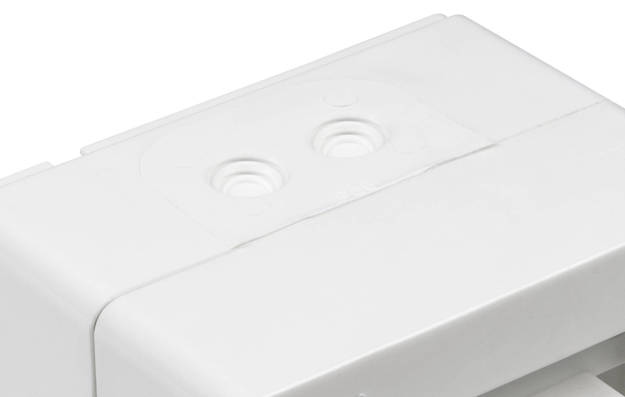 Gros plan d'un couvercle de dispositif en plastique blanc ou d'un emballage présentant deux indentations circulaires surélevées sur un fond épuré et minimaliste.