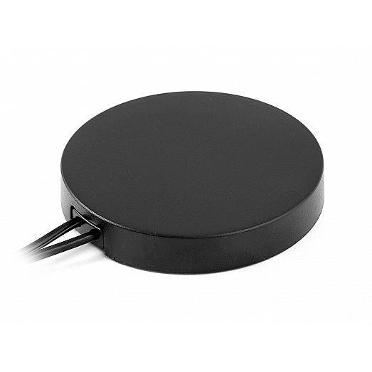 Rondelle électronique noire avec deux câbles s'étendant d'un côté sur un fond blanc.