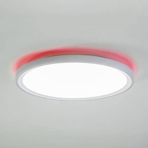 Luminaire de plafond circulaire avec un centre blanc brillant et un anneau extérieur rougeoyant sur un plafond gris uni.
