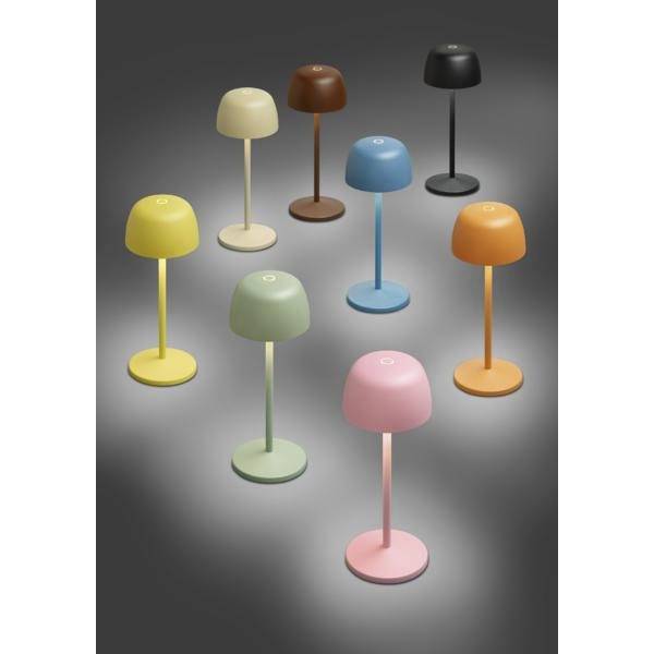 Huit lampes de table en forme de champignon coloré sur un fond gris, chacune avec une base ronde et une tige fine.