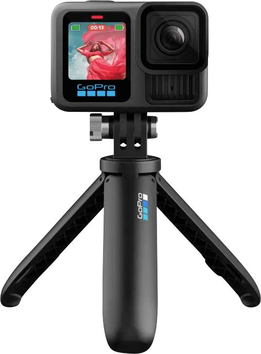 Caméra GoPro montée sur un petit trépied, affichant un écran avec une personne posant dans une robe rouge