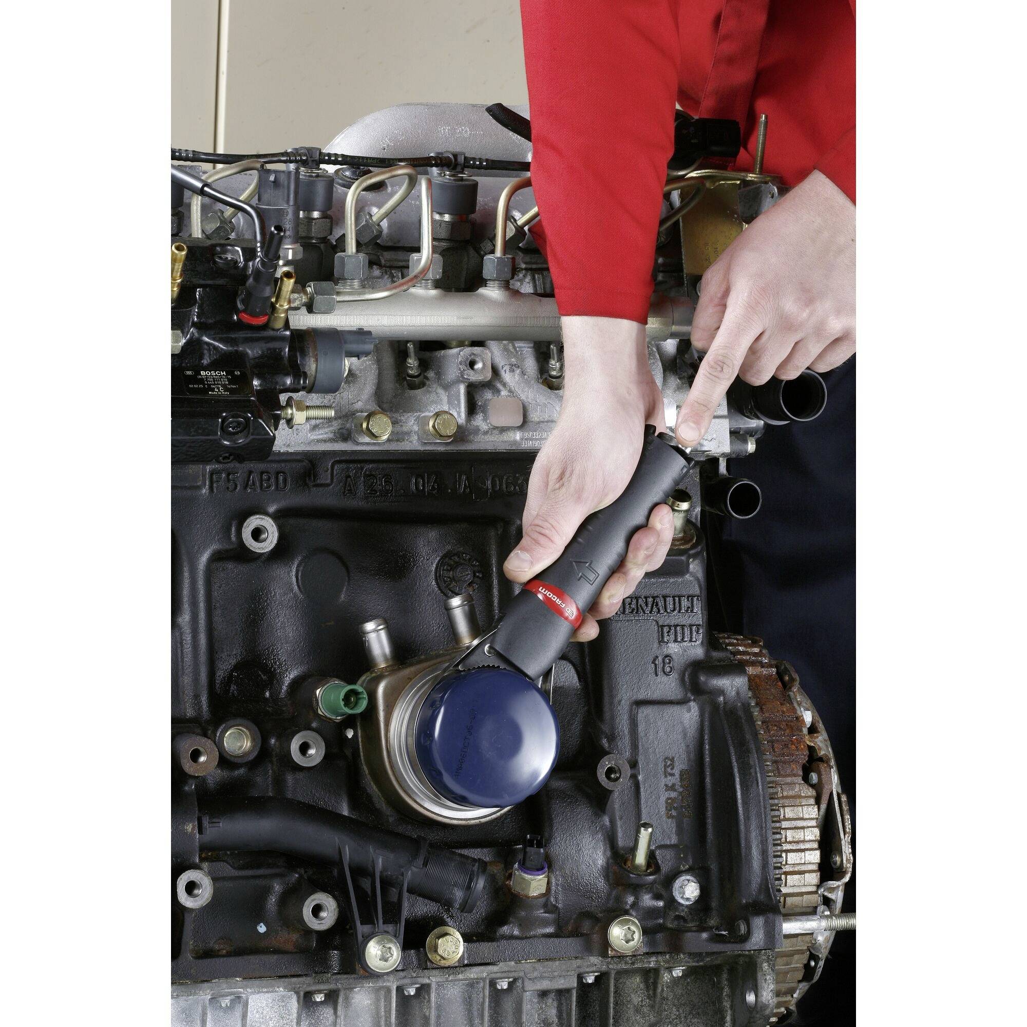 Un mécanicien utilisant un outil électrique pour serrer ou retirer un boulon sur un ensemble moteur.