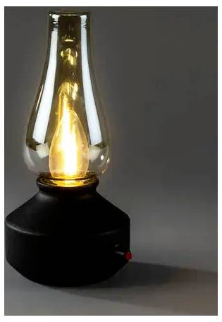 Lampe à huile en verre de style vintage allumée avec une base noire et une flamme brillante sur un fond gris.