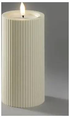 Bougie pilier cylindrique à côtes de couleur crème allumée sur une surface grise sur un fond gris.